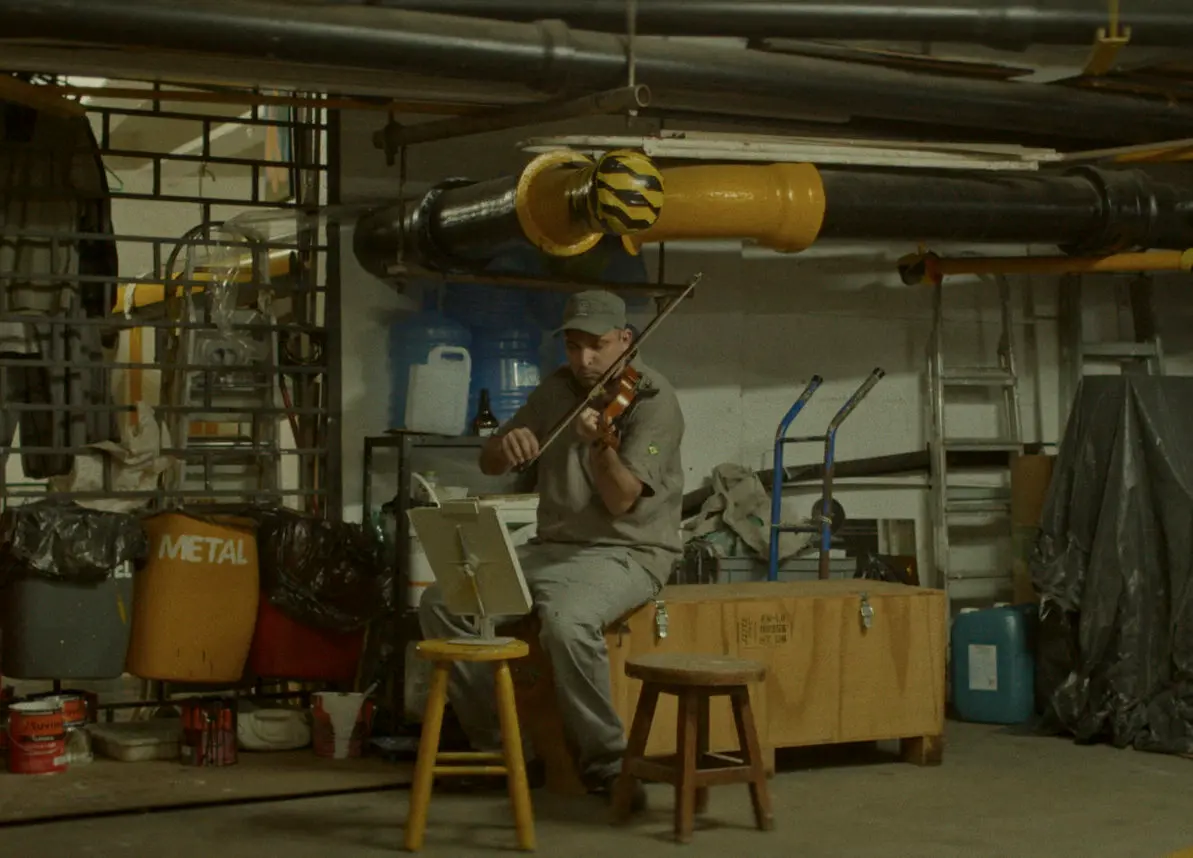 Funcionário toca o hino nacional no violino. <br> (Foto: divulgação)
